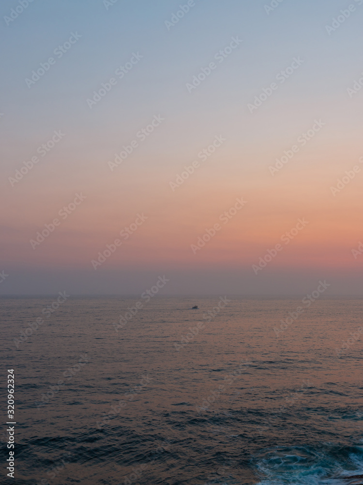 Fototapeta premium Orange colored sky in the morning over the ocean.