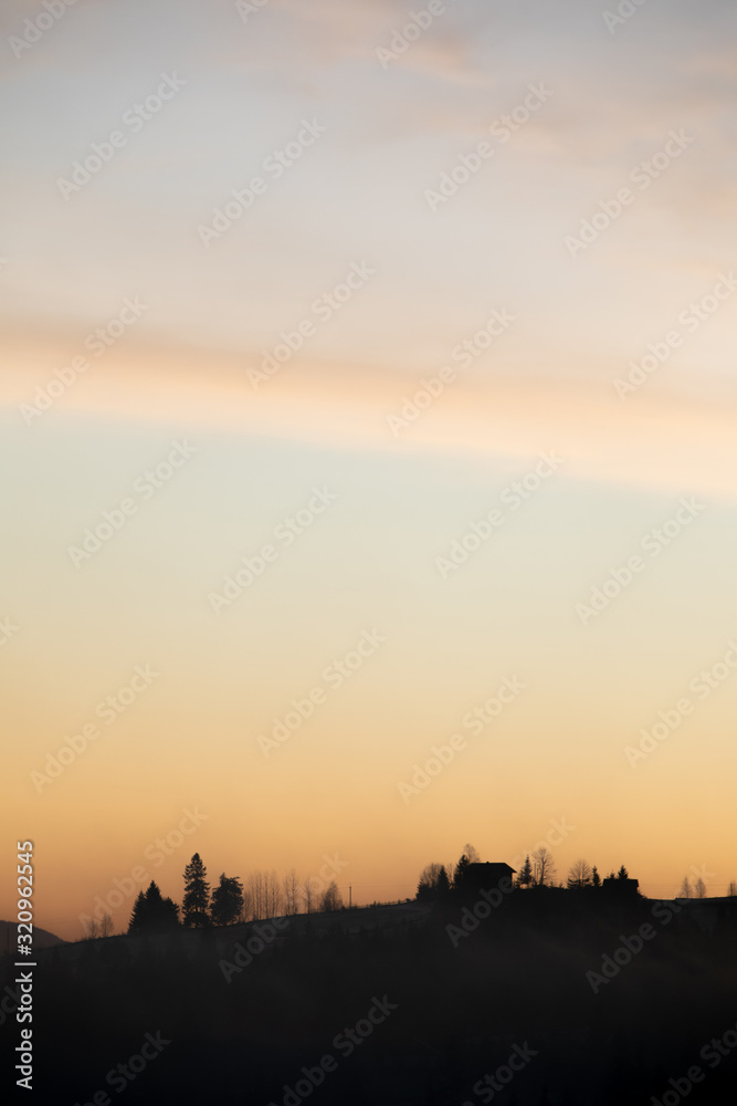 Naklejka premium silhouette of village in mountains on sunrise