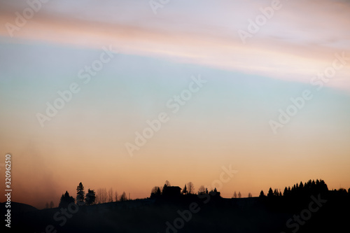 silhouette of village in mountains on sunrise © phpetrunina14