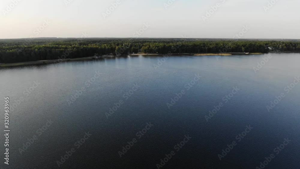 Aerial View of a Lake During a Summer Evening With Dense Forest in Background
