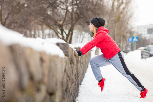 Woman wearing sportswear urban exercising outside during winter