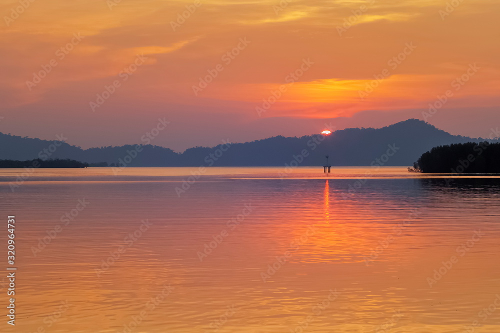 Sea view evening of sundown with red sun light and cloudy sky background, sunset at Kuraburi Pier, Phang Nga, southern of Thailand.