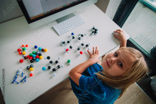 little girl making model of a molecule with computer program, learning chemistry, online learning and STEM