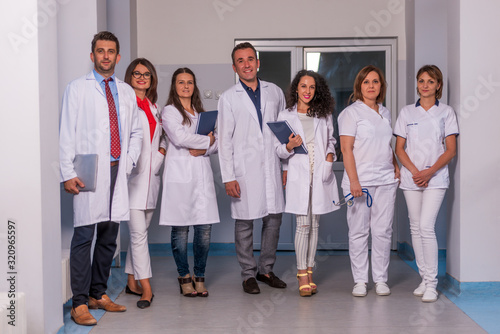 Group of medical staff, team doctors and nurses posing in the hallway of a hospital, clinic.