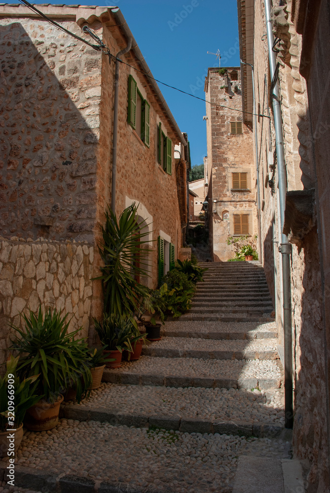 Alte enge Gasse mit Steinhäusern und Treppen in Fornalutx, Mallorca