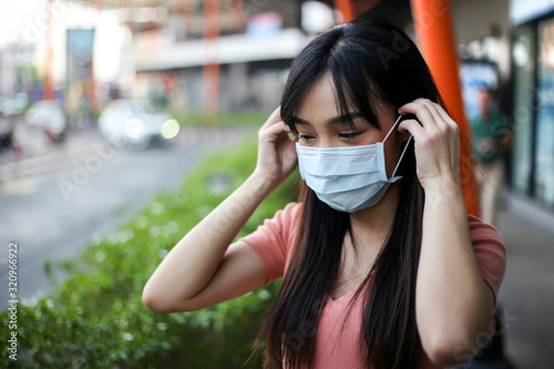 Beautiful asia woman wearing mouth mask against air smog pollution PM 2.5 and Coronavirus in the community,bangkok thailand.