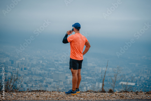 Senior athlete man drinking water from a bottle after jogging