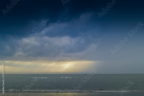 view evening of heavy raining in the sea with dark clouds background, sunset and raining at Laem Son Beach, Laem Son National Park, Ranong, southern of Thailand.