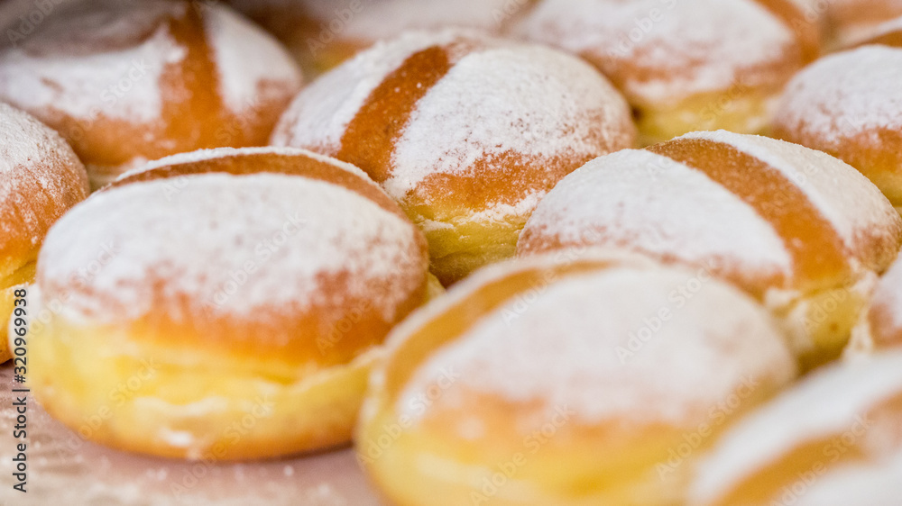 VIENNA, AUSTRIA - Jan 31, 2020: Close up of austrian Krapfen (english: doughnuts). Fried, with powdered sugar on top. Popular food in german speaking countries. Also known as Berliner. Sweet pastry.