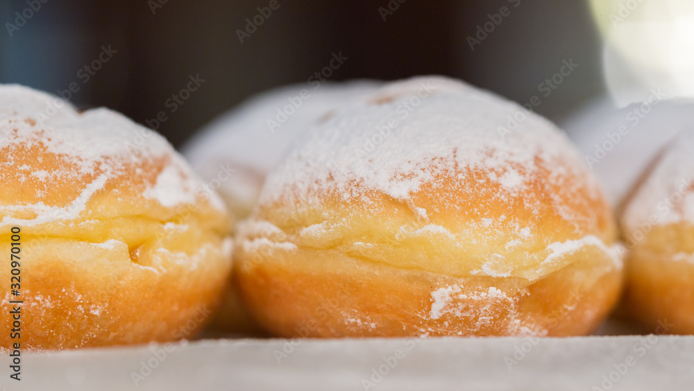 Side view (close up) of austrian Krapfen. In northern parts of Germany called Berliner. A doughnut, especially popular during carnival. Sweet with sugar on top. Side view (close up) of austrian Krapfen. In northern parts of Germany called Berliner. A doughnut, especially popular during carnival. Sweet with sugar on top.