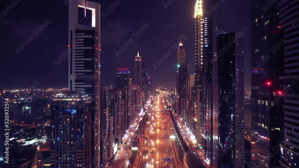 Aerial night illuminated Dubai city skyline skyscrapers view and  busy traffic on Sheikh Zayed road  highway