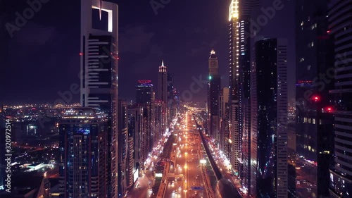 Aerial night illuminated Dubai city skyline skyscrapers view and  busy traffic on Sheikh Zayed road  highway photo