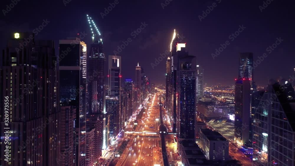 Aerial night illuminated Dubai city skyline skyscrapers view and busy traffic on Sheikh Zayed road highway Aerial night illuminated Dubai city skyline skyscrapers view and busy traffic on Sheikh Zayed road highway