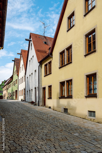 A typical narrow paved street with colorful traditional houses for the medieval town of Rothenburg ob der Tauber located on the famous Romantic Road in Bavaria Germany.