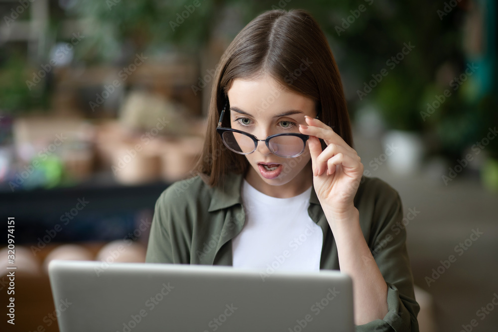 Girl in glasses working on a laptop is very surprised. Girl in glasses working on a laptop is very surprised.