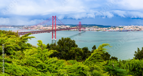 Landscape of Lisbon, Portugal skyline and the 25th of April bridge over the Tagus river estuary as seen from the hills of Almada