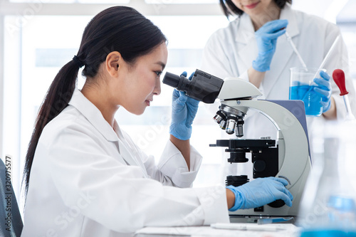 顕微鏡を覗き込む女性研究員