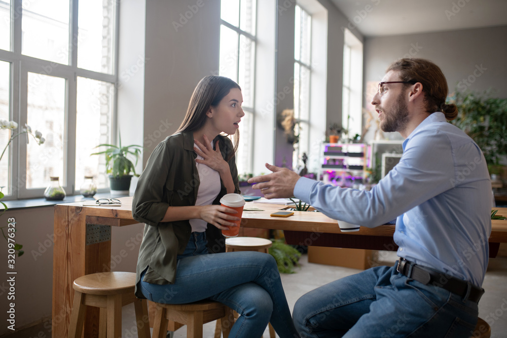 Girl and man talking at a table drinking coffee. Girl and man talking at a table drinking coffee.