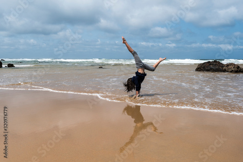 Child doing handstands at the beach at Phillip Island, Victoria Australia photo