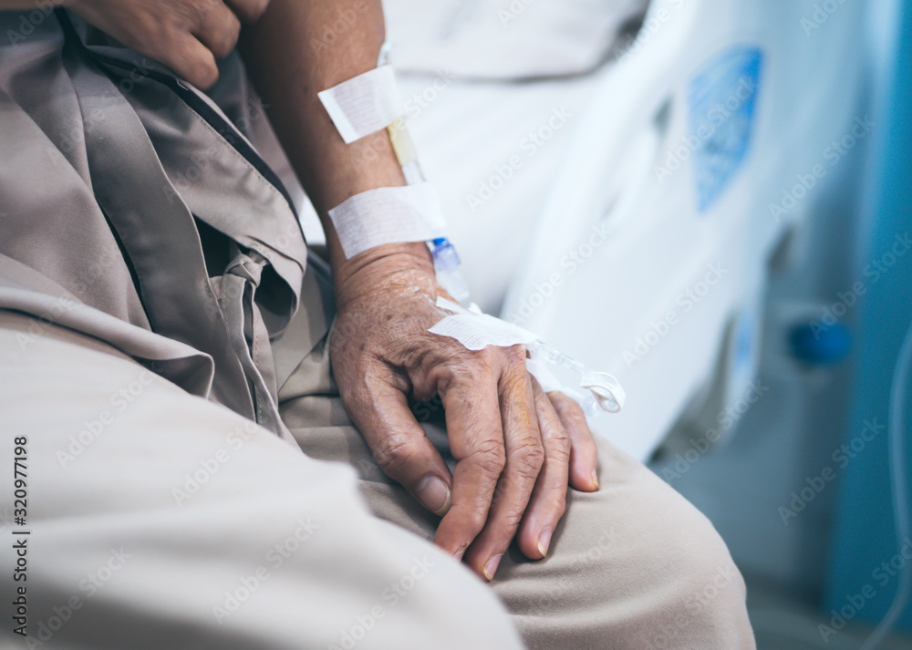 Focus on the hand of a patient in hospital while sitting at hospital bed. Focus on the hand of a patient in hospital while sitting at hospital bed.