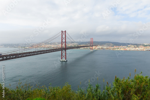 25 de abril bridge (25th of April Bridge), Almada, Portugal. Beautiful red suspension bridge connected to the portuguese capital of Lisbon. Often compared to the Golden Gate Bridge in San Francisco.