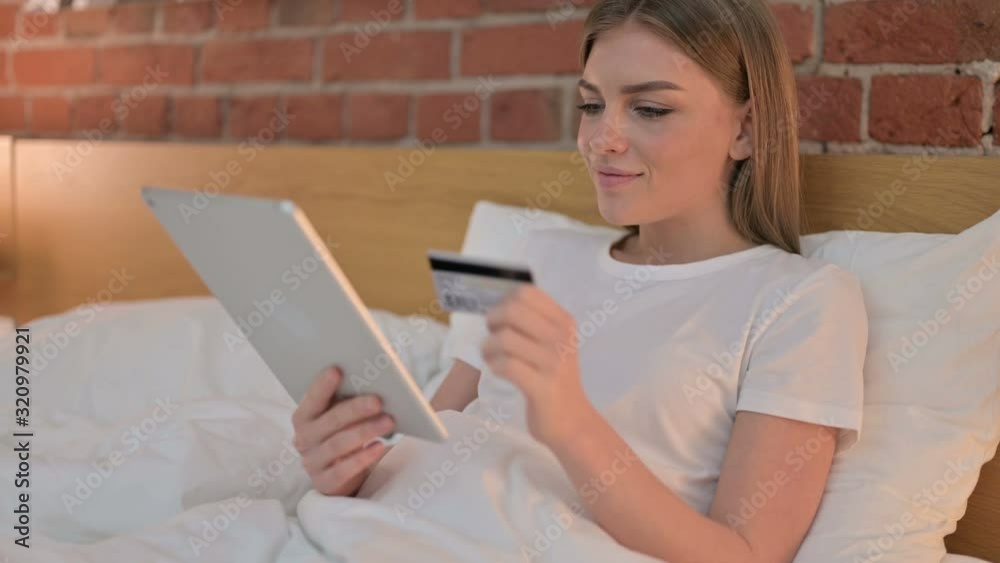 Ambitious Young Woman having Online Payment Success on Tablet in Bed Ambitious Young Woman having Online Payment Success on Tablet in Bed