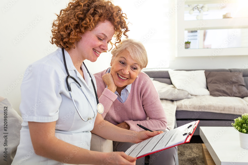 Young doctor filling up medical record with her patient. Health care form Medical doctor discusses with patient about the health examination results, happy senior patient with her doctor Young doctor filling up medical record with her patient. Health care form Medical doctor discusses with patient about the health examination results, happy senior patient with her doctor