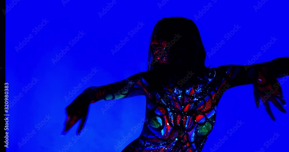 Woman with colorful body art and splashes of paint is dancing, uv light, 4k Woman with colorful body art and splashes of paint is dancing, uv light, 4k