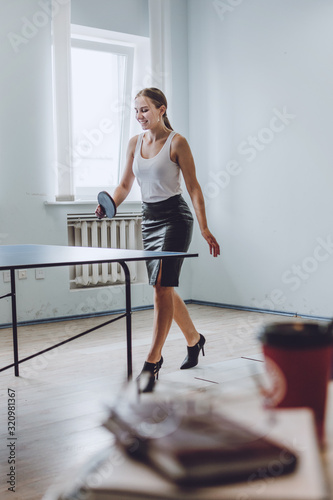 Lunch break activities concept. Office games during Lunch break. Attractive young Business woman playing ping pong, table tennis in office