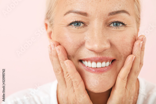Beautiful mature woman with healthy skin on color background, closeup