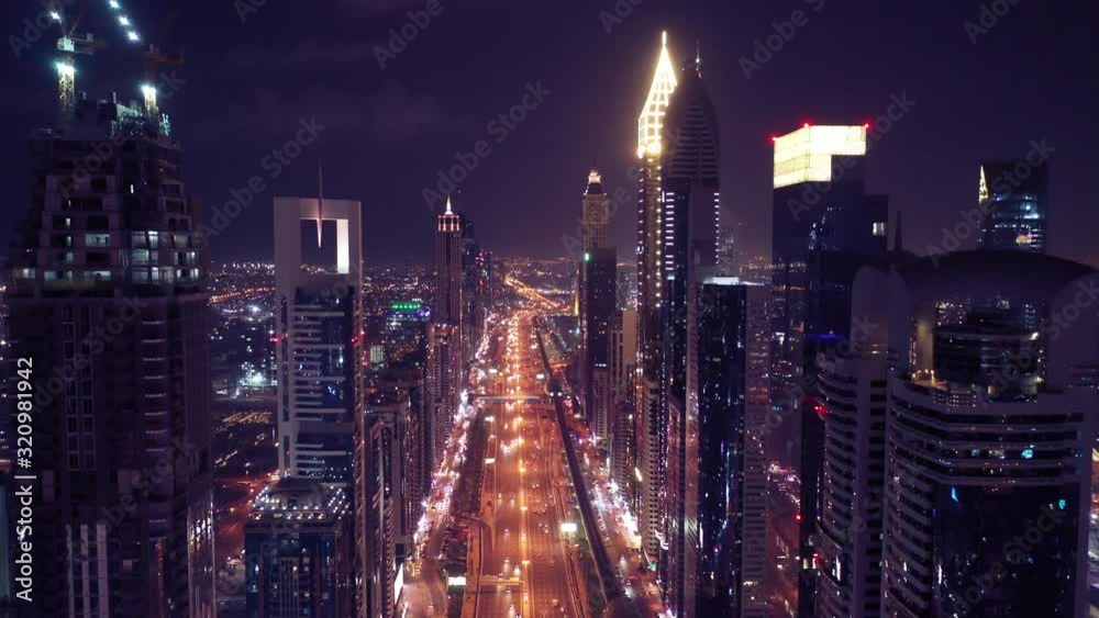 Aerial night illuminated Dubai city skyline skyscrapers view and busy traffic on Sheikh Zayed road highway Aerial night illuminated Dubai city skyline skyscrapers view and busy traffic on Sheikh Zayed road highway