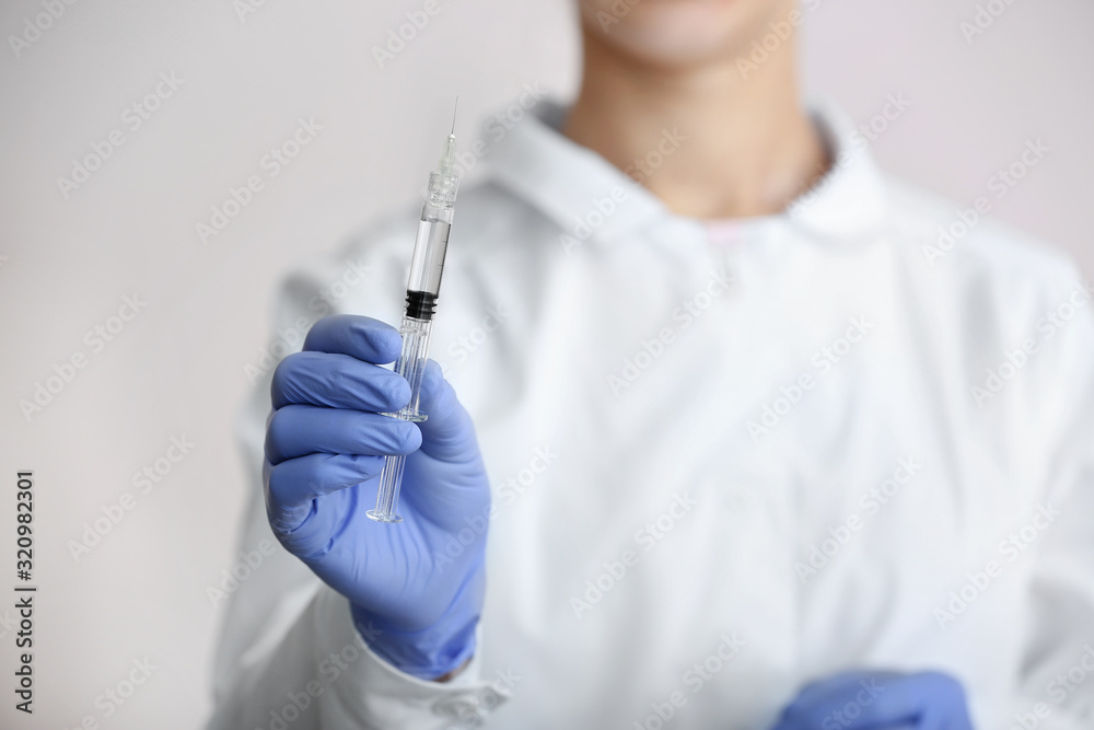 Cosmetologist holding syringe with filler for injection, closeup Cosmetologist holding syringe with filler for injection, closeup