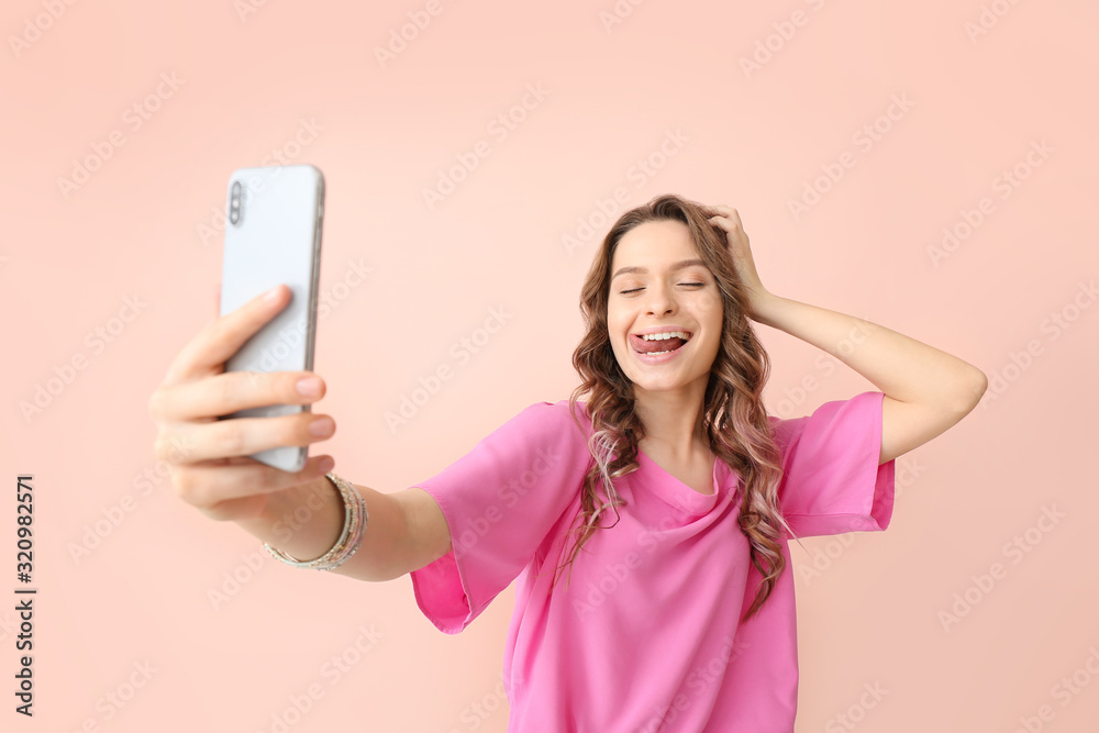 Young woman taking selfie on color background Young woman taking selfie on color background