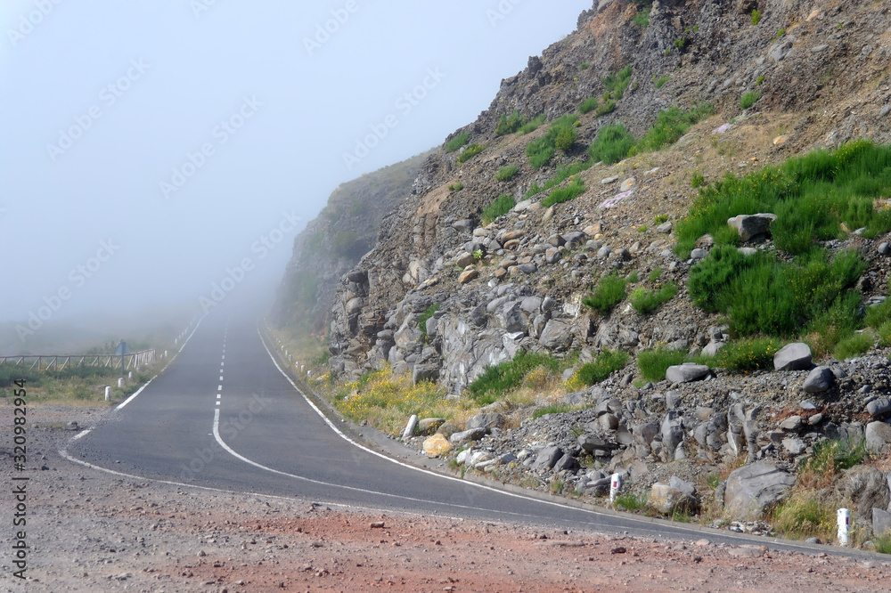 Mountain road disappearing into fog on Madeira island Mountain road disappearing into fog on Madeira island