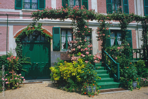 The house and home of Claude Monet at Gverny with rose coverd arches and plants and flowers photo