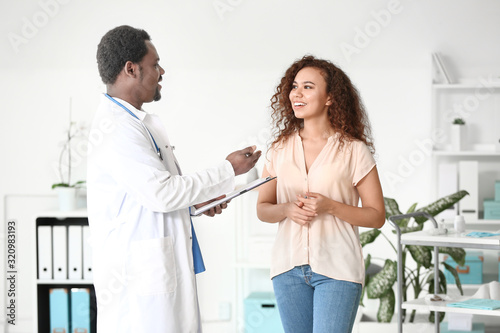 Male African-American doctor examining patient in clinic