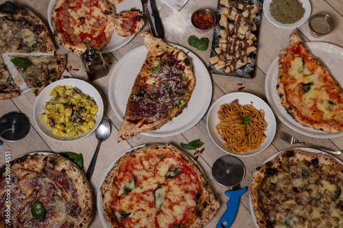 Overhead view on delicious varieties of freshly prepared Neapolitan Mediterranean dishes on wooden table