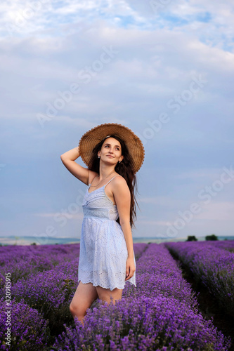 Young beautiful caucasian woman with hat in lavender field