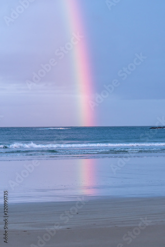 Rainbow over the ocean with clouds