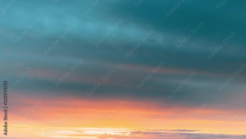 Sunset Sky. Bright Dramatic Sky With Fluffy Clouds. Yellow, Orange, Blue And Magenta Colours Sunset Sky. Bright Dramatic Sky With Fluffy Clouds. Yellow, Orange, Blue And Magenta Colours