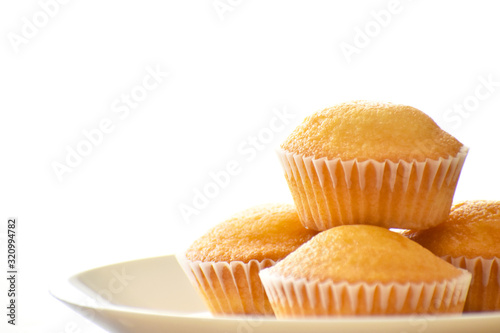 Muffin on a white plate on white background with copy space. Selective focus 