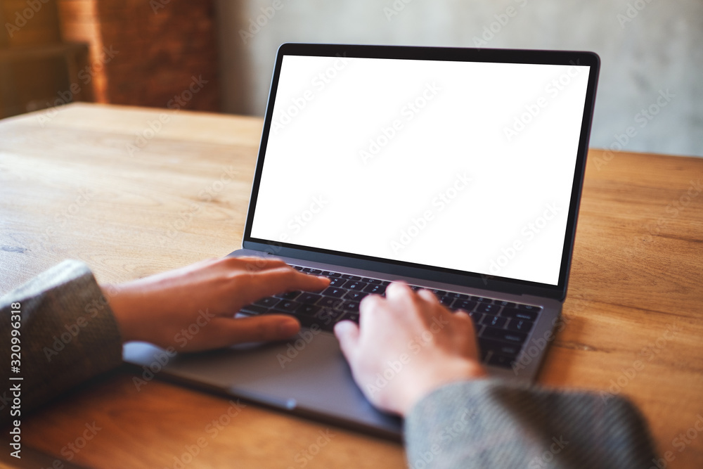 Mockup image of a woman using and typing on laptop computer with blank white desktop screen Mockup image of a woman using and typing on laptop computer with blank white desktop screen