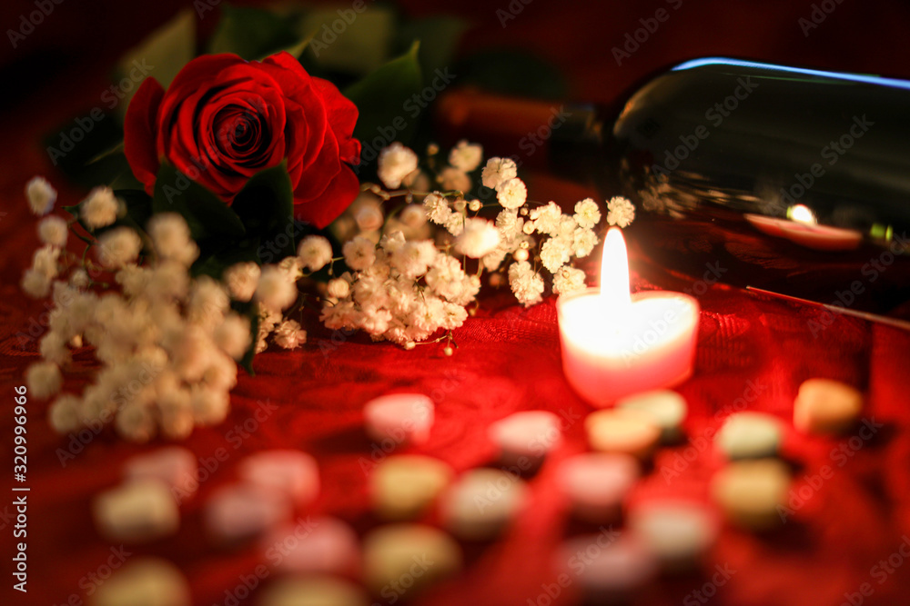 Red rose candlelight and wine. Table covered in red with flowers and candy hearts. Red rose candlelight and wine. Table covered in red with flowers and candy hearts.