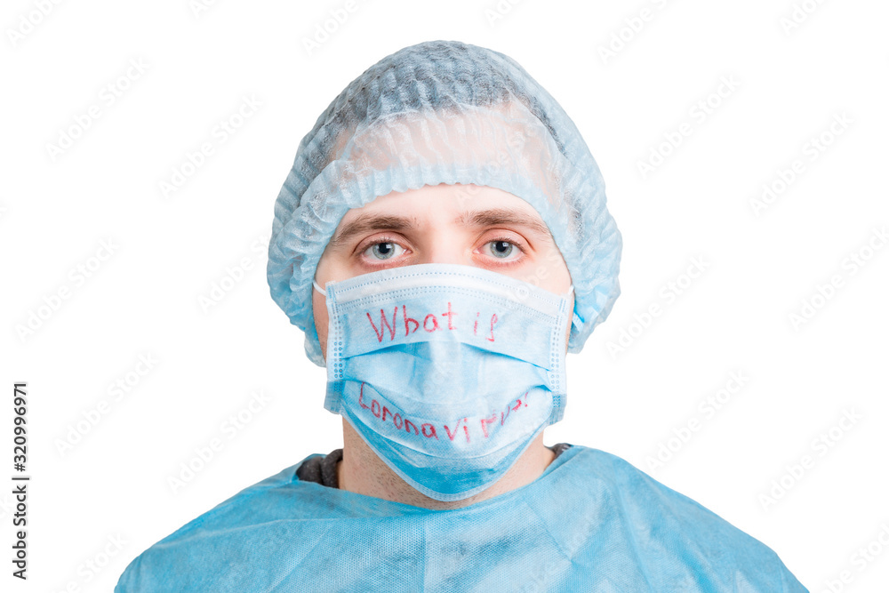 Portrait of young man wearing medical uniform and protective mask with what is coronavirus word isolated on white background. Coronavirus and health care concept Portrait of young man wearing medical uniform and protective mask with what is coronavirus word isolated on white background. Coronavirus and health care concept