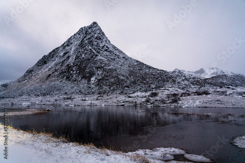 Evening winter landscape with mountain above a lake, Lofoten islands, Norway.