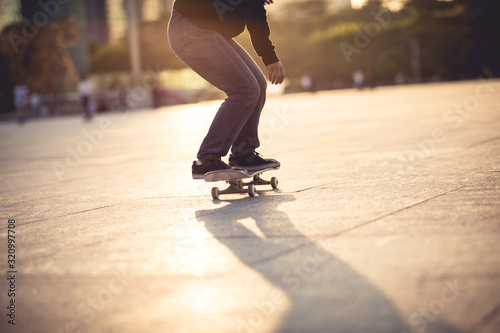 Photography Skateboarder skateboarding at sunset city