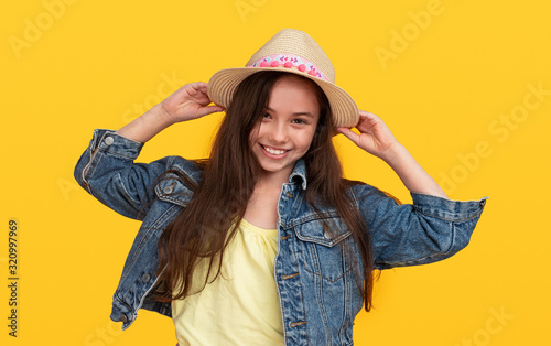 Happy fashionable preteen girl on yellow background © kegfire