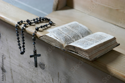 Rosenkranz und Gebetbuch auf einer Kirchenbank der Kapelle 