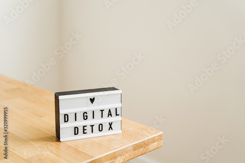 Digital detox day. Lightbox on wooden background and white walls. Gadget ban