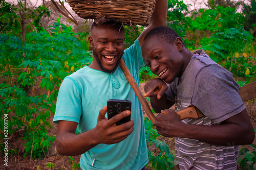 young black men in the farm going through things on the phone photo